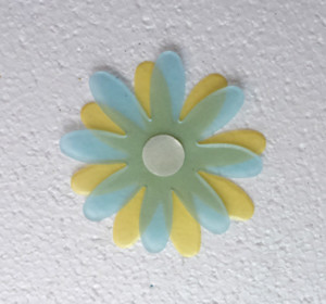 Using the 1/2" punch, punch a flower from the KoolTak Punch Adhesive Sheet and adhere it to the center of the top flower. Pinch the edges of the petals, then add a second  1/2" punched circle on the back of the top flower and adhere it to the bottom flower.